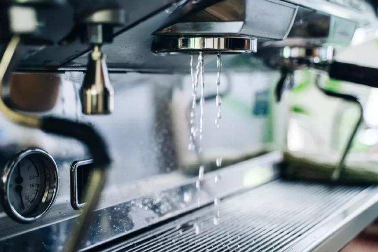 Macchina del caffè professionale che sgocciola acqua durante il processo di pulizia