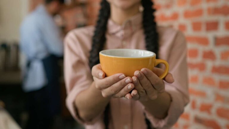 Caffè offerto dalle mani di una ragazza