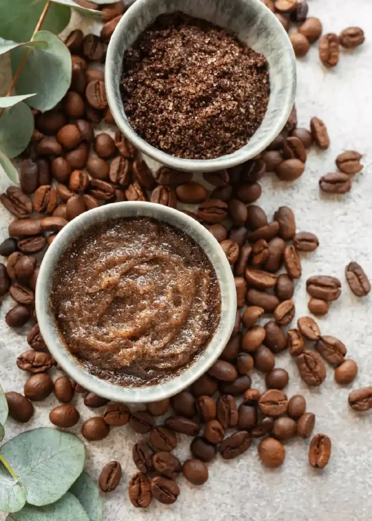 Due tazze con caffè macinato in polvere e scrub al caffè viste dall'alto