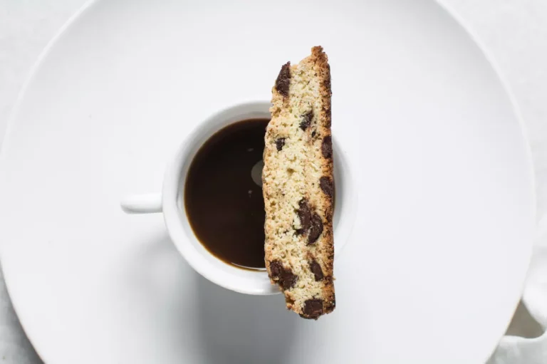 tazza di caffè ripresa dall'alto con biscotto cantuccio appoggiato
