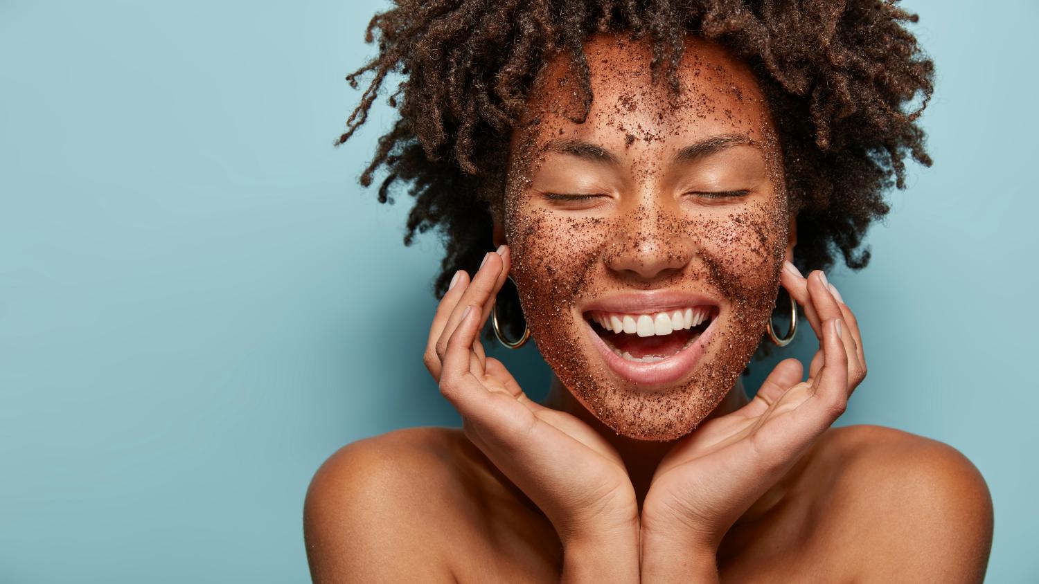 Ragazza sorridente con occhi chiusi con caffè sul viso