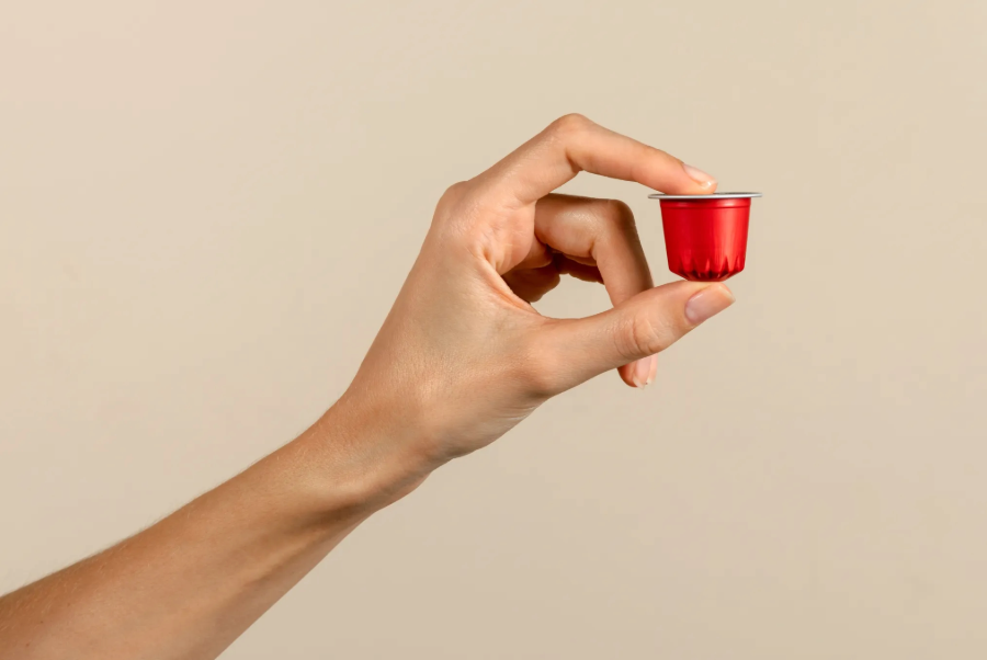 Visione laterale di una mano che tiene una capsula