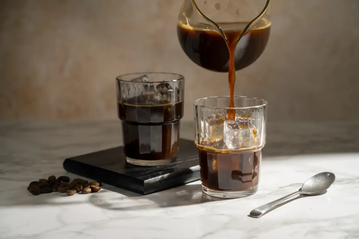 bicchieri di diverse forme con cold brew coffee su piano in marmo