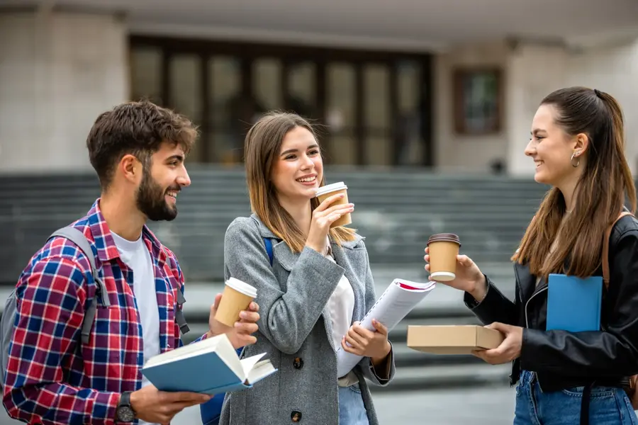 tre studenti parlano e sorseggiano caffè