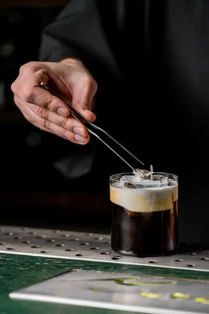mano con attrezzo da barman per decorazione cold brew