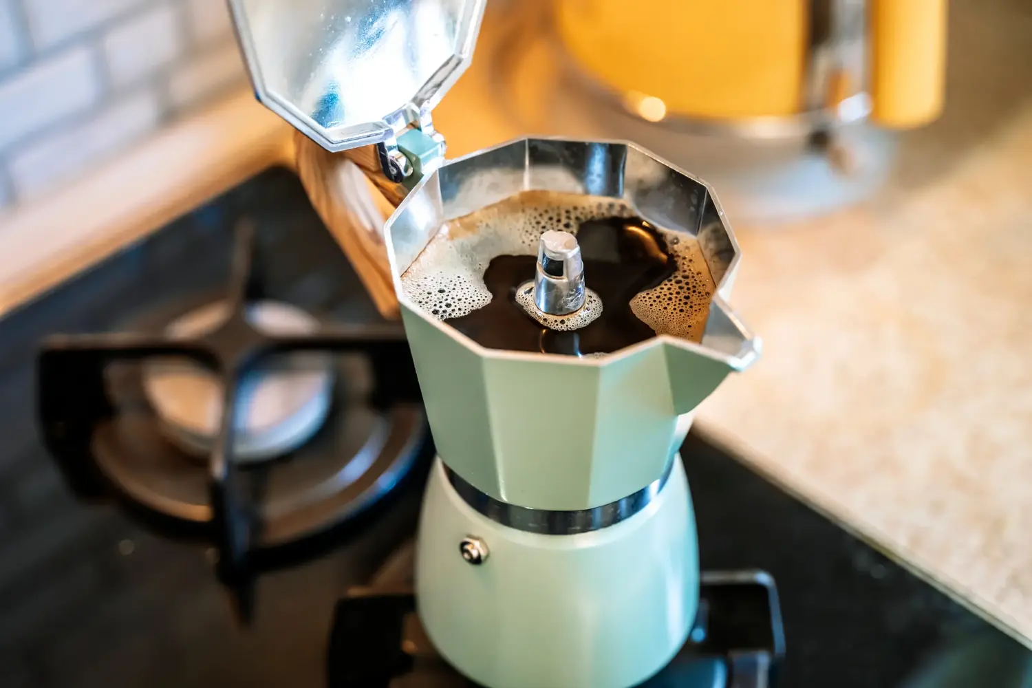 caffettiera aperta con caffè sul piano cottura
