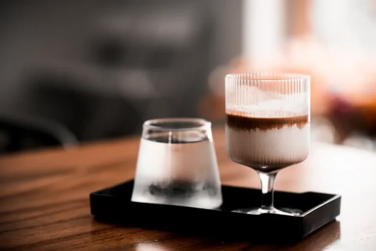 tavolo con vassoio e bicchieri di caffè e acqua